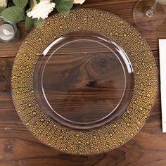 an empty plate on a wooden table with flowers