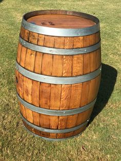 a wooden barrel sitting on top of a lush green field