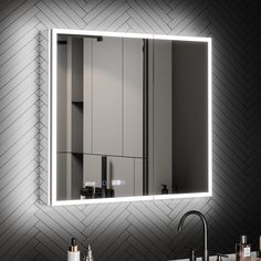 a bathroom sink with a mirror above it and lights on the wall next to it