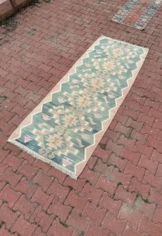 a blue and white rug sitting on top of a brick road next to a fire hydrant