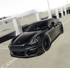 a black sports car parked in an empty parking lot