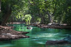 a river that is surrounded by trees and rocks