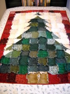 a quilted christmas tree sitting on top of a bed next to bookshelves