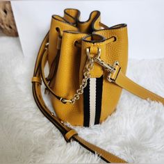 Authentic Bally Mustard Leather Nwot Bucket Bag. Has Black And White Stripe On Each Side. Gold Hardware. Detachable Adjustable Crossbody Strap. Comes With Care Card, Dust Bag, And Paper Bag! Size Is 7” W X 7” H All My Items Are From A Smoke Free Home. If You Have Any Questions Feel Free To Reach Out. Thank You For Looking Yellow Leather Shoulder Bag With Branded Hardware, Gold Leather Bucket Bag, Gold Leather Bucket Shoulder Bag, Evening Yellow Shoulder Bag With Branded Hardware, Luxury Yellow Bucket Bag With Removable Pouch, Classic Gold Bucket Shoulder Bag, Chic Gold Bucket Satchel, Elegant Yellow Bag With Branded Hardware, Elegant Yellow Bags With Branded Hardware