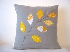 a gray pillow with yellow leaves on it