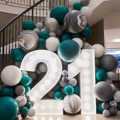 the number twenty two is surrounded by balloons and streamers in front of a spiral staircase