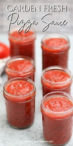 four jars filled with pizza sauce sitting on top of a table