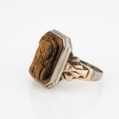 This is part of Chairish’s Fine Jewelry assortment.  Finely detailed vintage Art Deco era tigers eye cameo ring crafted in 10 karat white & yellow gold (circa 1920s to 1930s).   Tigers eye measures 16mm x 12mm. The tiger's eye is in good condition (few very minor chips visible under a 10x loupe).   The tigers eye cameo depicts the side profile of two Centurions. The tiger's eye is luminous with warm golden hues visible with every movement of the ring. The square mount has a low profile and rises Gold Coin Ring, Byzantine Gold, Yellow Gold Sapphire Ring, Medieval Rings, Chrysoprase Ring, Gold Amethyst Ring, Costume Rings, Tiger Eye Jewelry, Cameo Jewelry