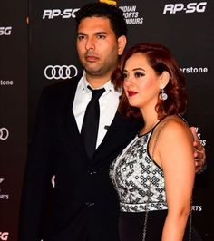 a man and woman standing next to each other on a red carpet at an event