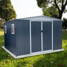 a blue shed sitting on top of a lush green field