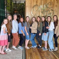 a group of young women standing next to each other in front of a coffee shop