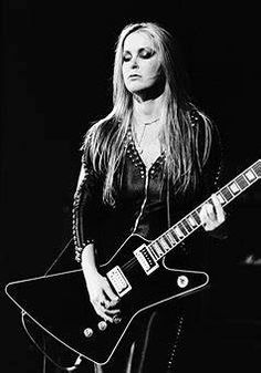 a black and white photo of a woman playing an electric guitar