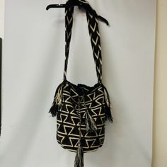 - Brown, Tan, And Black -Handwoven Bucket Style Bag -Wear Shoulder Or Cross-Body -Drawstring With Tassels -100% Acrylic Yarn And Glass Crystals -Handmade In Columbia -Comes With Extra Crystals Handmade Black Bucket Bag For Travel, Black Woven Straw Crossbody Bag, Black Woven Crossbody Bucket Bag, Handmade Black Crossbody Bucket Bag, Black Woven Satchel Shoulder Bag, Bohemian Black Handwoven Shoulder Bag, Black Bohemian Handwoven Shoulder Bag, Black Woven Satchel Straw Bag, Black Woven Straw Satchel Bag