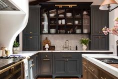 a kitchen with gray cabinets and white counter tops