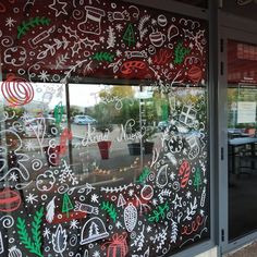 the window is decorated with christmas decorations and writing on it's glass, along with other holiday themed items