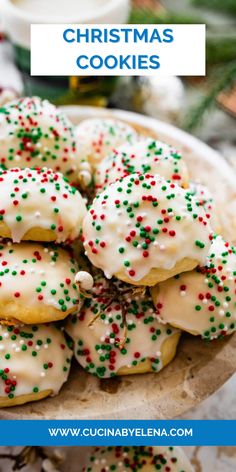 christmas cookies with white icing and sprinkles on a plate