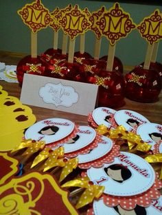 a table topped with lots of red and yellow candy sticks covered in paper cut outs