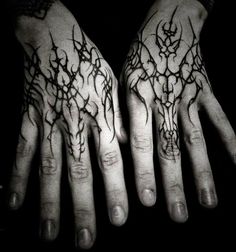 two hands that have tattoos on them