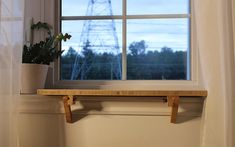 a window sill with a potted plant on it in front of a window