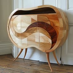 an unusual wooden cabinet sitting on top of a hard wood floor next to a white door