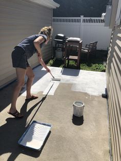 a woman is painting the outside of her house