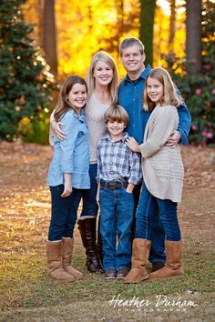 a family posing for a photo in the woods