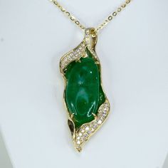 Discover the allure of our unique and elegant designer pendant. This extraordinary piece showcases a large natural Colombian cabochon emerald, exquisitely adorned with round brilliant cut diamonds. The diamonds, beautifully accentuate the breathtaking emerald. Crafted in 14K yellow gold, this pendant is a testament to exceptional craftsmanship and timeless elegance. Make a statement with this one-of-a-kind masterpiece that effortlessly captures attention and admiration. SPECIFICATIONS: 1982658 Gemstone: Natural Colombian Emerald, cabochon. Weight: 17.0ct.  Side Stones: 0.65ct of various sizes round brilliant cut diamonds. Colour: F G. Clarity: SI Material: 14K yellow gold. Total Weight: 13.34 grams. Dimensions: 50.0 x 21.0mm approx. Our family-owned business consists of gemmologists, miner Luxury Emerald Pendant Necklace With Diamond Accents, Exquisite Emerald Jewelry With Cabochon, Exquisite Emerald Cabochon Jewelry, Exquisite Green Jewelry With Pave Setting, Luxury Jade Pendant Jewelry, Emerald Cabochon Pendant Jewelry, Diamond Cabochon Pendant Necklace, Colombian Emerald Ring, Green Stone Necklace