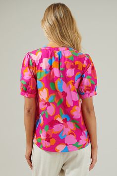 You'll be thriving all day long when you step out in the Daphne Floral Neli Split Neck Top! It has a gorgeous pink multi floral design all over. This classic top t has short puff sleeves followed by a split neckline that forms into V-neck. Wear it with high waisted white pants or matching pink pants for a stylish fit! - Split neck- Puff sleeves- Breathable- Relaxed fit- Color: Fuchsia MulSize + Fit - Model is 5'8" and wearing size XS- Measurements taken from size S - Chest: 20 1/4"- Length: 24 3 Feminine Floral Print Short Sleeve Top, Feminine Short Sleeve Floral Print Top, Feminine Multicolor Short Sleeve Blouse, Multicolor Floral Print Short Sleeve Blouse, Multicolor Floral Print Puff Sleeve Tops, Multicolor Puff Sleeve Top With Floral Print, Spring Pink Short Sleeve Top With Relaxed Fit, Pink Short Sleeve Top With Relaxed Fit For Spring, Casual Pink Blouse With Vibrant Print