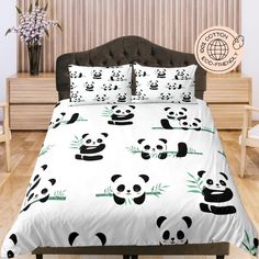 a bed with panda bears and bamboo leaves on it