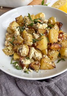 a white bowl filled with potatoes and cheese