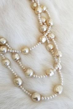 "This is a vintage 1940's Original by Robert necklace. The stands are made from hand painted glass beads made to look like baroque style pearls. They have a variety of color tones from ivory to off white from age and previous wear. They have been restrung in a previous ownership and one of the strands was mis-strung and overlaps with another strand. The clasp has a chipping on one of the hand-painted pearls. The clasp has pearl tone beads, AB rhinestones, and clear rhinestones. The signature is Evening Pearl Necklace With Round Beads, Elegant Cream Necklaces With Large Beads, Gold Pearl Necklace With Large Beads, Silver Pearl Necklace With Large Beads, Elegant Cream Jewelry With Large Beads, Large Beads Pearl Necklace For Jewelry Making, Elegant Large Bead Pearl White Necklace, Elegant Large Beaded Pearl White Necklace, Elegant Pearl White Necklace With Large Beads