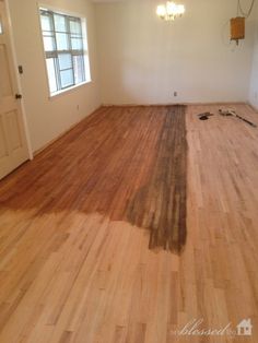 an empty room with hard wood flooring and bare walls in the background is a door