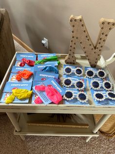 a wooden table topped with lots of crafting supplies on top of a carpeted floor