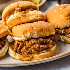 three sloppy joe sandwiches on a plate