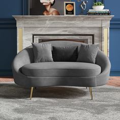 a grey couch sitting in front of a fireplace