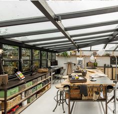 a room filled with lots of wooden furniture and shelves under a roof covered in windows