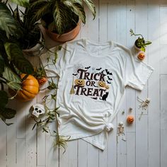 Trick or treat-themed t-shirt perfect for Halloween celebrations. Made with 100% Airlume combed and ring-spun cotton, this lightweight tee is breathable and ideal for active and leisure wear. The retail fit and crew neckline add a classic style that's perfect for casual and semi-formal settings. Suitable for both men and women. Product features - 100% Airlume combed and ring-spun cotton - Lightweight fabric (4.2 oz/yd²) - Retail fit for casual and semi-formal settings - Various fabric blends ava White Themed Tops For Halloween, White Themed Top For Halloween, Halloween Themed White Tops, Themed White T-shirt For Fall, White Halloween Themed Tops, Pre-shrunk Themed T-shirt For Halloween, Halloween Themed Pre-shrunk T-shirt, Themed White T-shirt For Halloween, Themed Halloween T-shirt With Custom Print