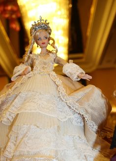 the doll is wearing a white dress and tiara