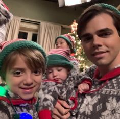 a group of people wearing christmas sweaters and hats