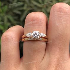 a woman's hand with a three stone ring on top of her finger,