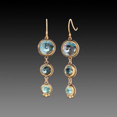 Brilliant topaz stones in varying shades of blue are wrapped in 22k gold, and accented with a tiny 22k gold trio. Sparkly and wonderful for a special occasion or just to brighten every day. Setting measurements range from approximately 3/8 - 1/4 inch wide. 22k bezels with silver backing. Earrings hang approximately 1 5/8 inches from top of 18k gold ear wires. Matte finish. Gold Drop Earrings With Blue Topaz, Blue Topaz Earrings With Gemstone Accents, Faceted Blue Topaz Dangle Earrings, Blue Topaz Multi-stone Earrings, Multi-stone Blue Topaz Earrings As Gift, Roman Jewelry, Topaz Stone, 22k Gold, Pretty Jewellery