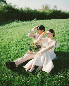 two people sitting in the grass together