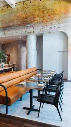 an empty restaurant with tables and benches in the foreground, along with chairs on either side