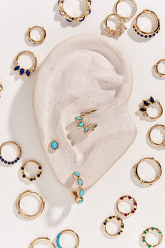 various rings and earring sets on a white surface