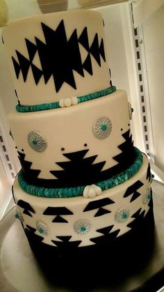 a three tiered cake with black and white designs