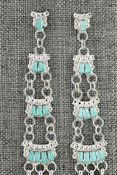 This intricately crafted turquoise and sterling silver necklace and earrings set was made by Zuni silversmith Lucy Sheeyka. The back of the pendant is signed LS and Zuni.Necklace: 22"Pendant:Length: 1 3/8"Width: 1 1/4"Earrings:Length: 3 1/8"Width: 5/8"Free shipping on all orders! We ship with USPS and always include tracking. All orders ship within a day of payment.Returns are accepted up to 30 days after you receive your order. Just send us a message. Our shop offers cash back or store credit. Turquoise Dangle Jewelry Stamped 925, Elegant Sterling Silver Turquoise Dangle Necklace, Silver Turquoise Dangle Necklace In Sterling Silver, Turquoise Dangle Necklace In Sterling Silver, Silver Dangle Turquoise Necklace In Sterling Silver, Turquoise Oxidized Dangle Jewelry, Turquoise Dangle Jewelry With Oxidized Finish, Artisan Turquoise Pierced Jewelry, 4 Earrings