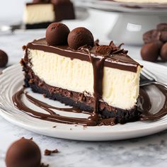 a piece of cheesecake on a white plate with chocolate candies around the edge