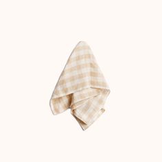 a tan and white checkered napkin on a white background