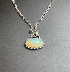 Opal is 9 carat natural untreated Semi Tranlucent white with Laser Rainbow Pattern, fire from all directions. Handmade sterling silver bezel and hand carved silver back detail.   This Opal is a stunner and the price is amazing. White Gold Jewelry With Sterling Silver Clasp, Oval White Gold Jewelry With Sterling Silver Clasp, White Gold Opal Oval Necklace, Oval Opal Necklace In White Gold, White Gold Opal Necklace With Oval Shape, Silver Opal Necklace Fine Jewelry, Silver Opal Necklace In Fine Jewelry Style, White Gold Opal Pendant Jewelry, Round Untreated Jewelry As A Gift