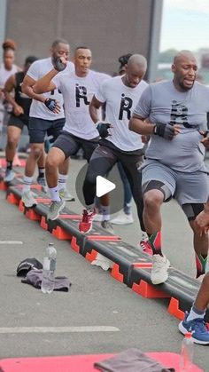 a group of men running on top of orange and black blocks in a race track